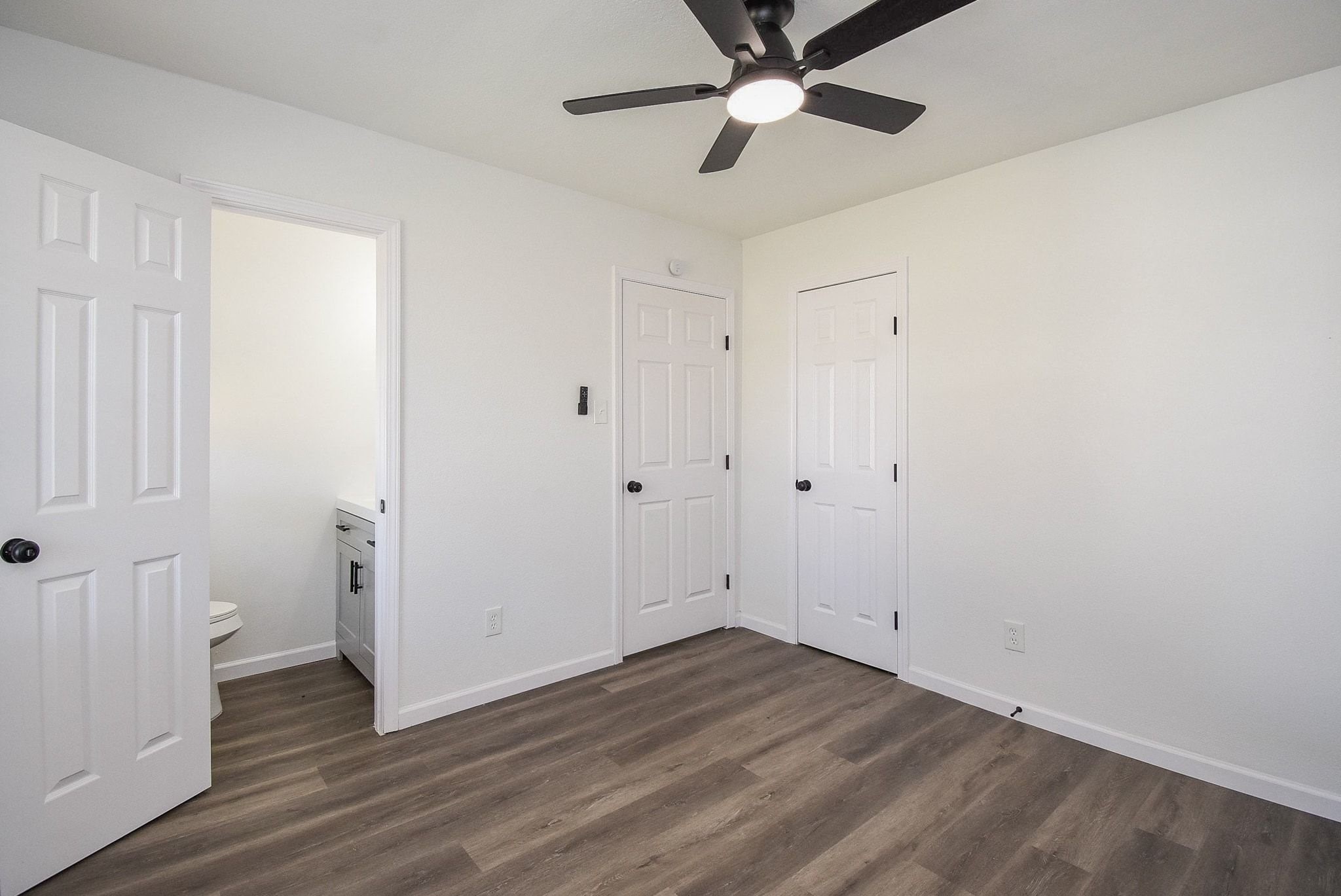 514 Peach Spring Drive Houston, TX 77037 - Photo 22 of 27 an empty room with wooden floor and ceiling fan