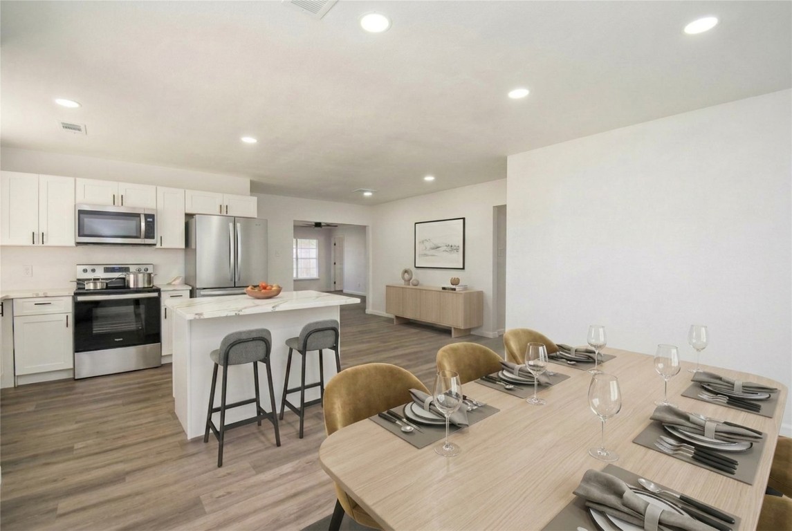 514 Peach Spring Drive Houston, TX 77037 - Photo 5 of 27 a kitchen with a table chairs stove and microwave