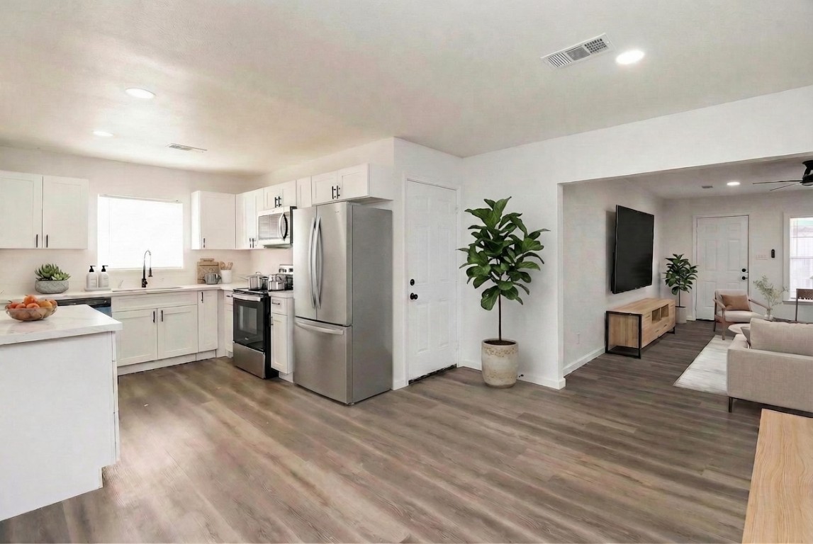 514 Peach Spring Drive Houston, TX 77037 - Photo 9 of 27 a kitchen with white cabinets and white appliances