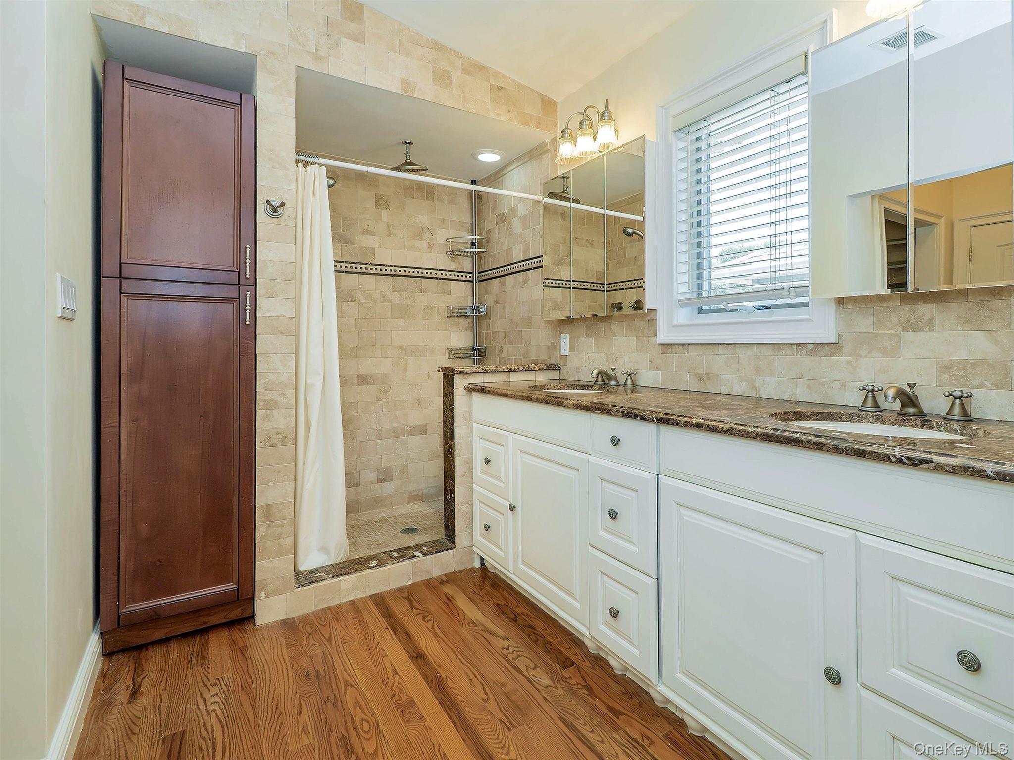 21 Marwood Road North Port Washington, NY 11050 - Photo 19 of 35 a bathroom with a sink a mirror and shower