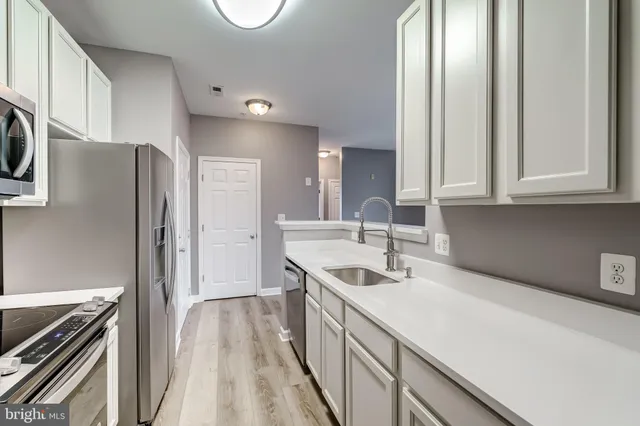 a kitchen with stainless steel appliances granite countertop a sink and a refrigerator