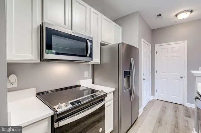 a kitchen with stainless steel appliances a stove a microwave and cabinets
