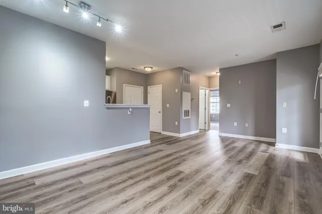 a view of an empty room with wooden floor