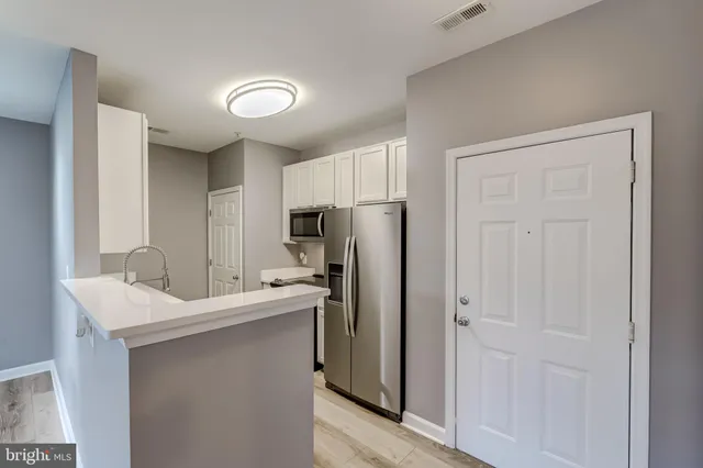 a kitchen with a sink a refrigerator and cabinets
