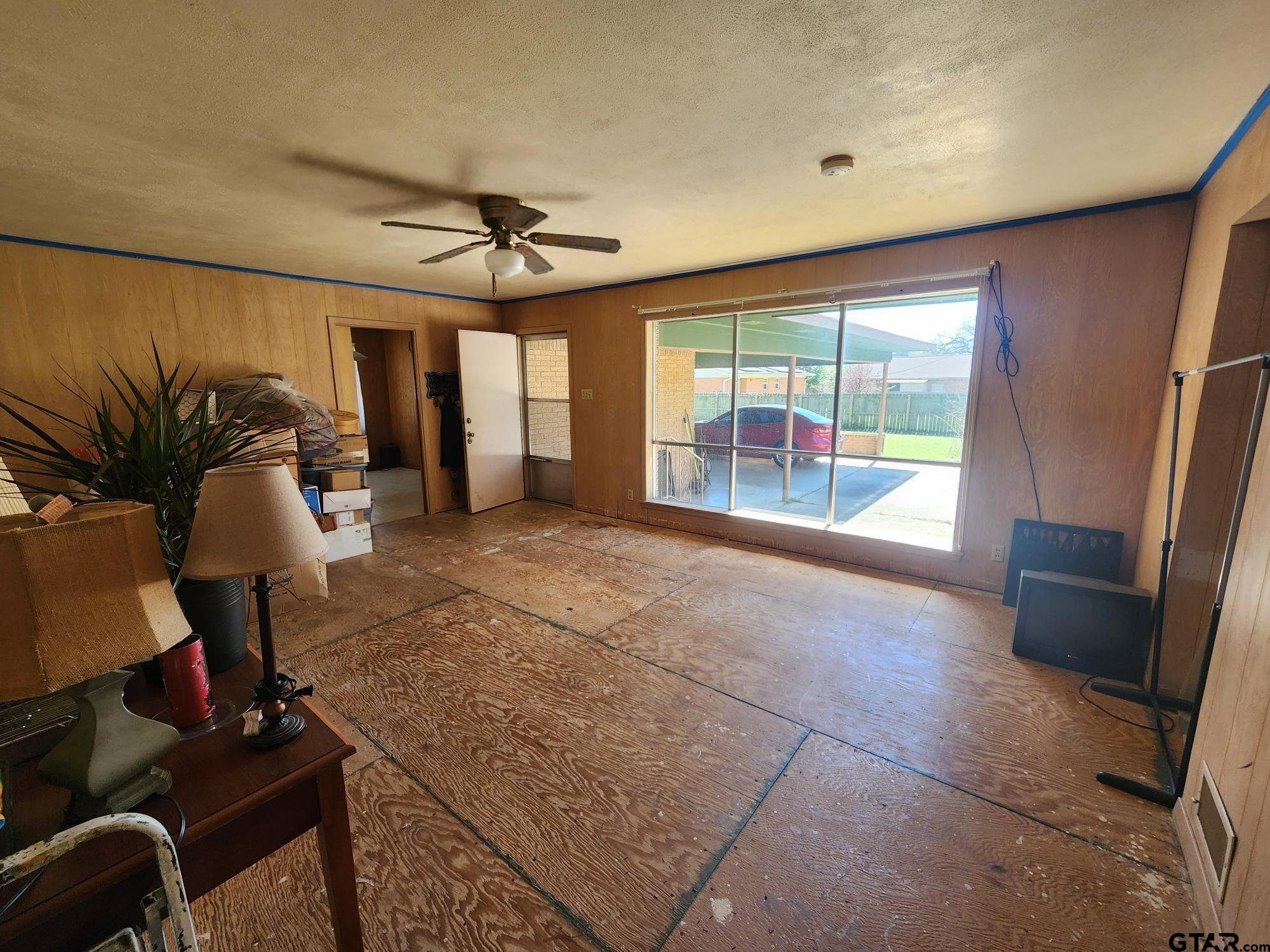 512 E Lane Quitman, TX 75783 - Photo 23 of 32 a living room with furniture a flat screen tv and a floor to ceiling window