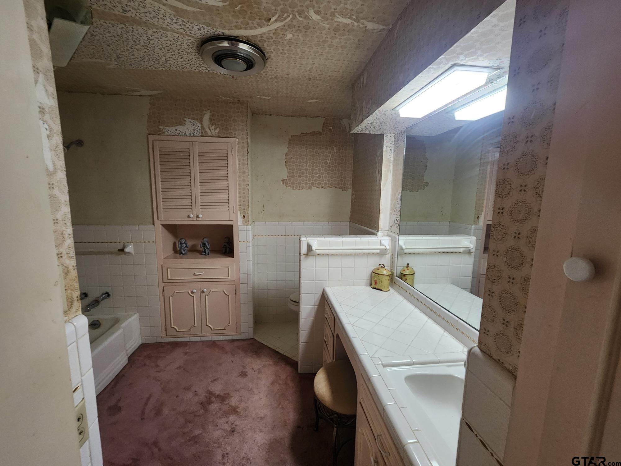 512 E Lane Quitman, TX 75783 - Photo 24 of 32 a bathroom with a sink a toilet a mirror and shower