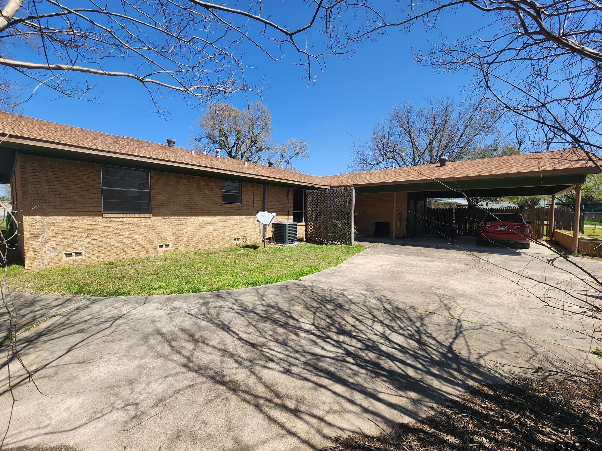 512 E Lane Quitman, TX 75783 - Photo 6 of 32 a front view of a house with a yard and garage