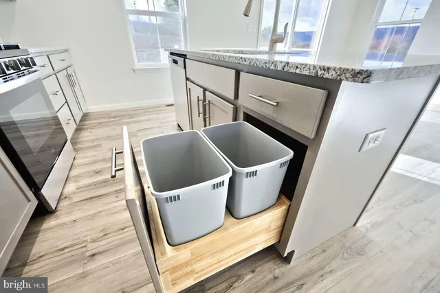 a kitchen with stainless steel appliances kitchen island wooden floors and white cabinets