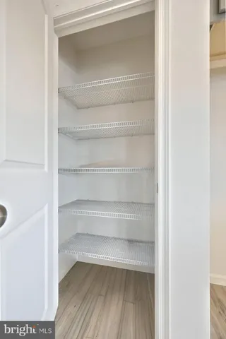 a view of a hallway with wooden floor and windows