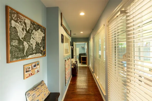 a hallway with white cabinets and window
