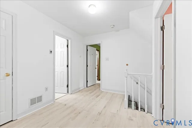 a view of a hallway with wooden floor and entryway