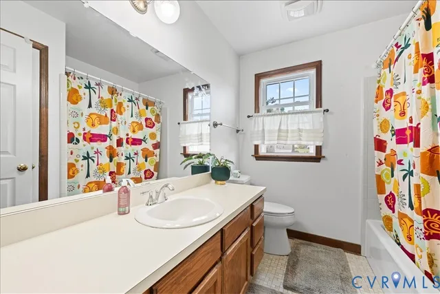 a bathroom with a sink a toilet and shower curtain