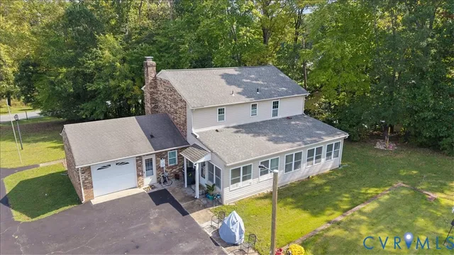 an aerial view of a house with swimming pool next to a yard