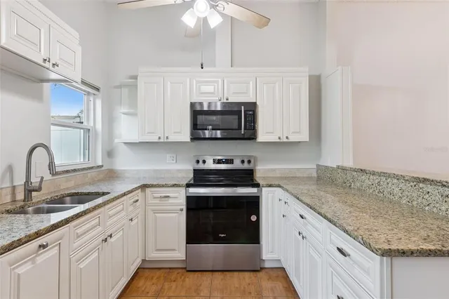 a kitchen with stainless steel appliances granite countertop a stove sink and cabinets