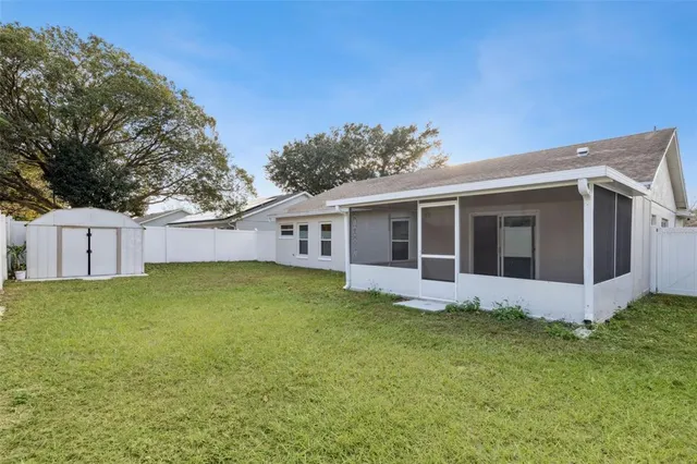 a view of a backyard with plants and large tree