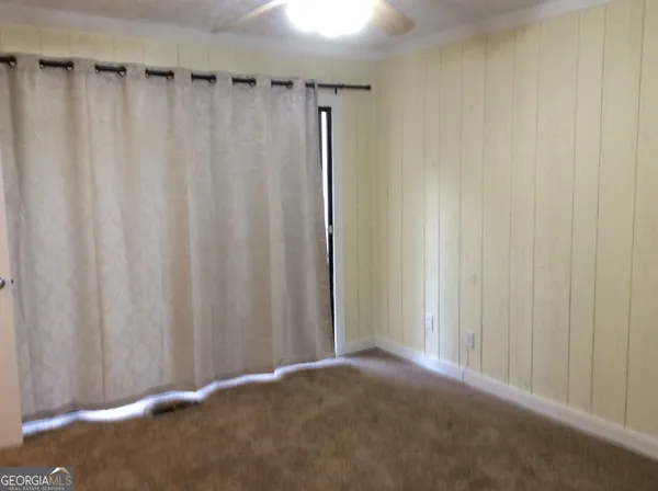 a view of a hallway with windows and chandelier