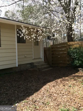 a view of backyard with wooden floor and large trees