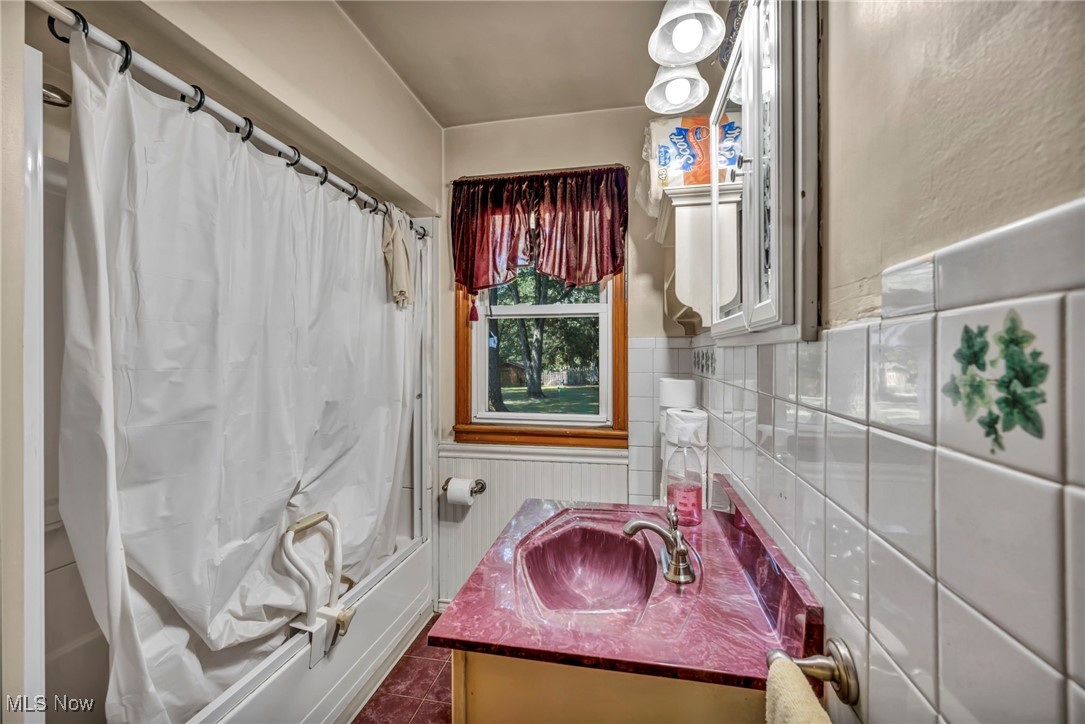 11858 Ridge Road North Royalton, OH 44133 - Photo 22 of 38 Full bath featuring wainscoting, vanity, shower / bath combo with shower curtain, and dark tile patterned flooring