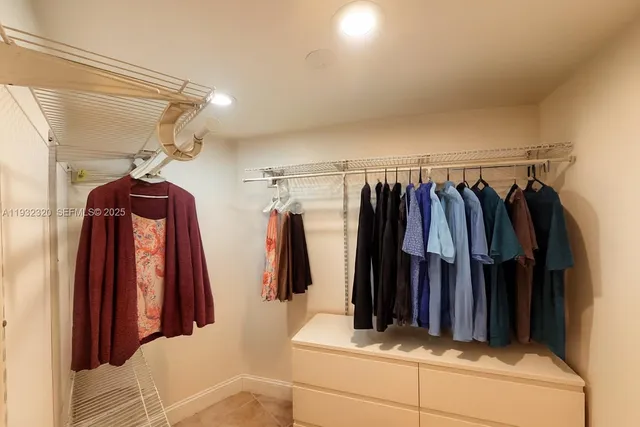 a view of walk in closet with clothes and shoes