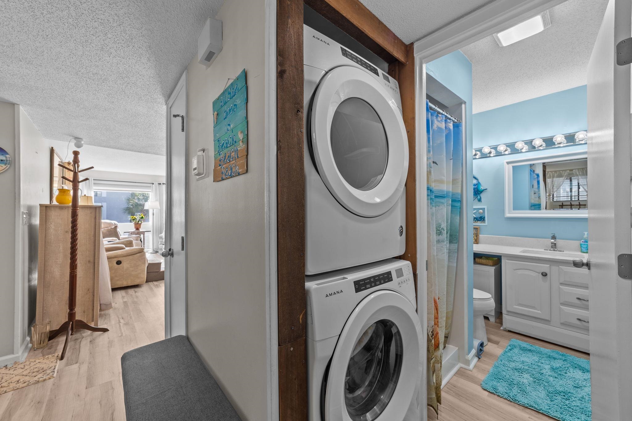 351 Lake Arrowhead Road, Unit 211 Myrtle Beach, SC 29572 - Photo 12 of 40 Laundry area featuring a textured ceiling, stacked washer / drying machine, and light wood finished floors