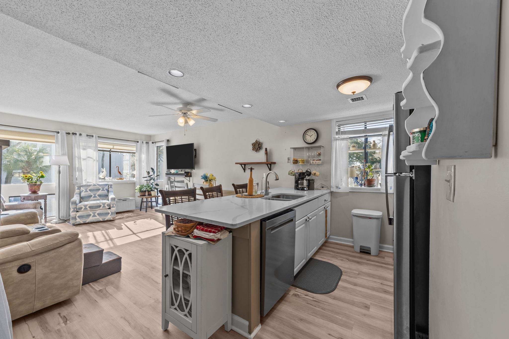 351 Lake Arrowhead Road, Unit 211 Myrtle Beach, SC 29572 - Photo 40 of 40 Kitchen featuring open floor plan, a peninsula, a textured ceiling, appliances with stainless steel finishes, and light stone counters