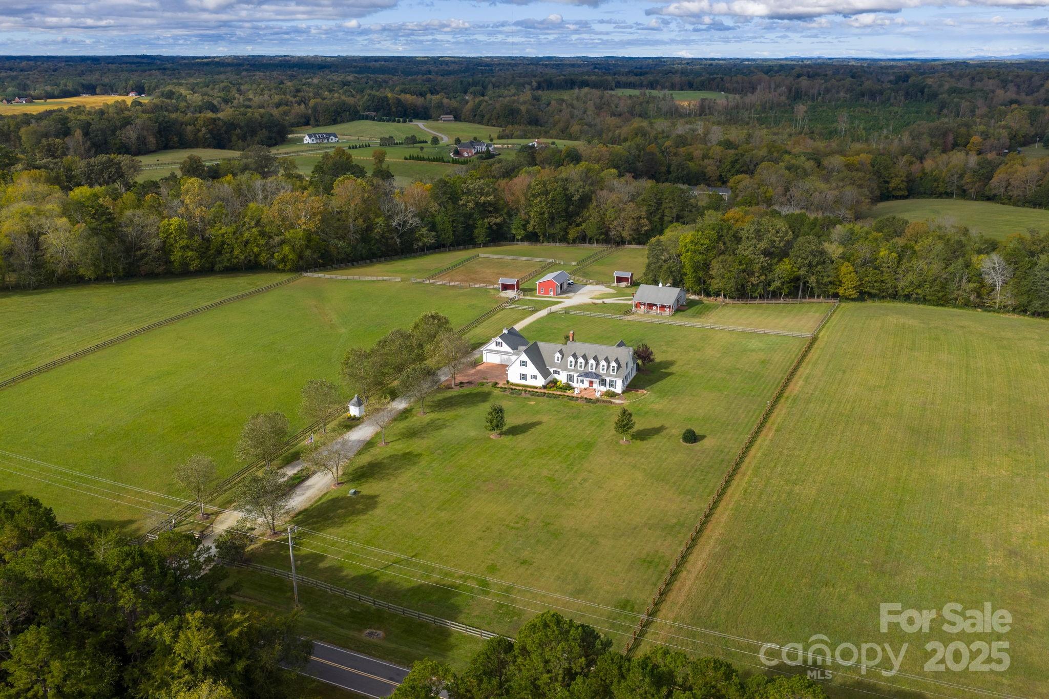 a view of a swimming pool with a yard and large trees