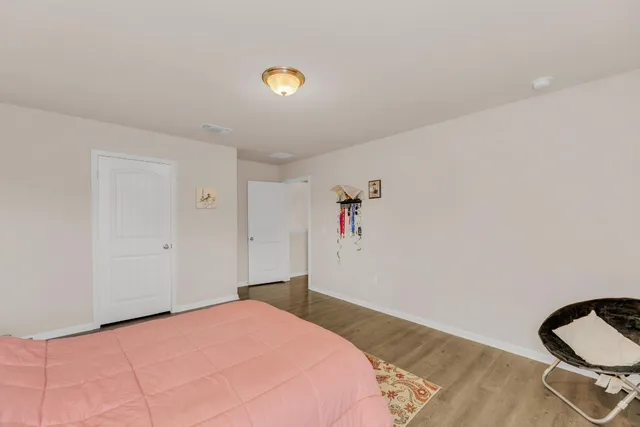 a bedroom with a bed and a stove with wooden floor