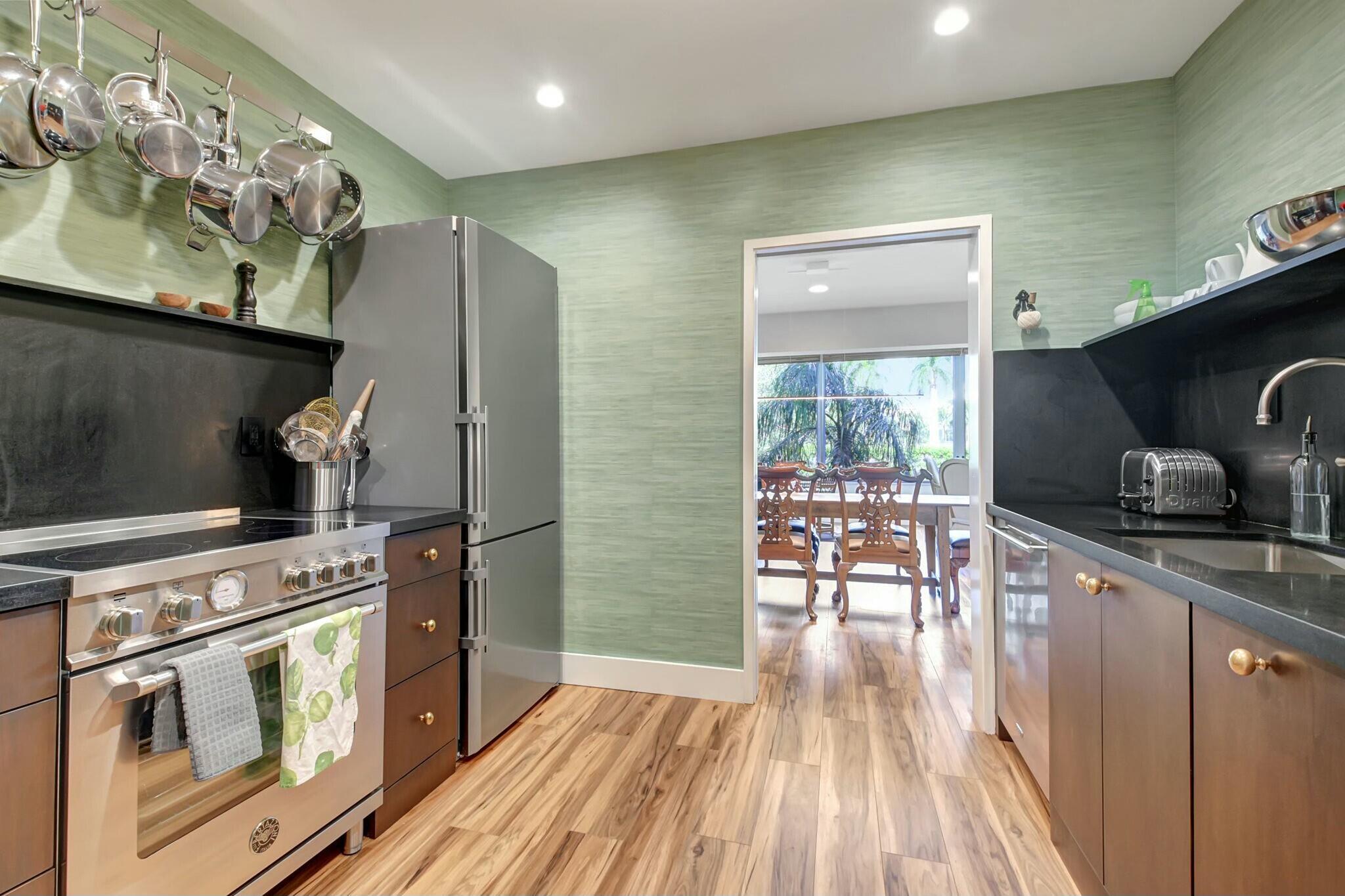 44 Cocoanut Row, Unit 104A Palm Beach, FL 33480 - Photo 11 of 26 a kitchen with stainless steel appliances granite countertop a stove and a wooden floors