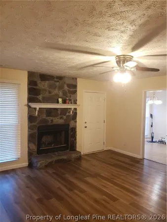 a view of empty room with wooden floor and fireplace