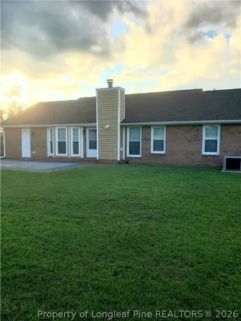 a view of a house with a big yard and large trees