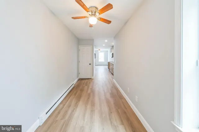 a view of a hallway with wooden floor