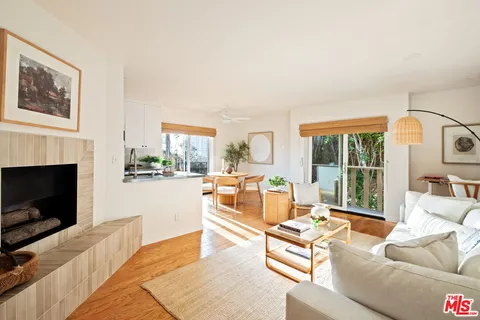 a living room with furniture fireplace and a large window