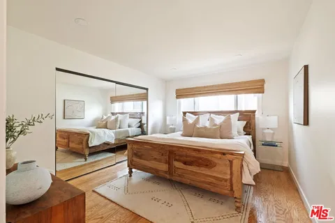 a bedroom with a bed and wooden floor