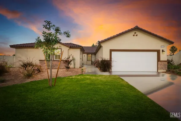 a view of a house with a yard and a patio