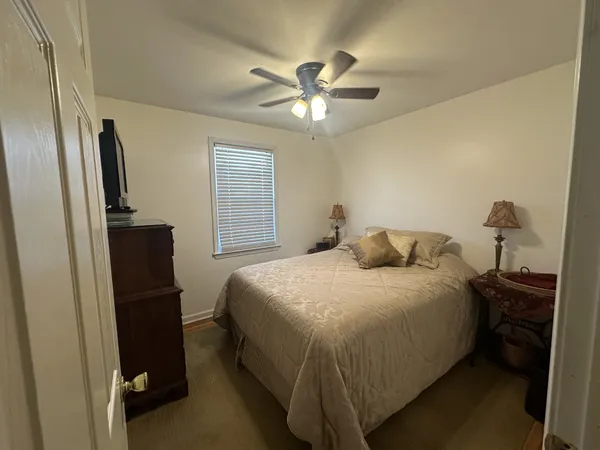 a bedroom with a bed and a refrigerator