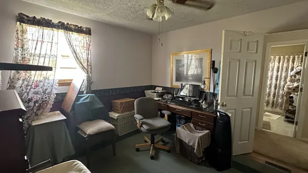 a view of a workspace with furniture and a window