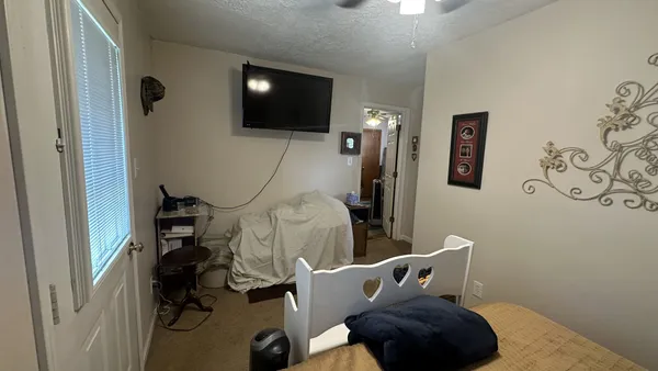 a bedroom with furniture and a flat screen tv