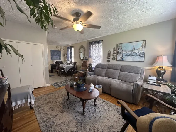 a living room with furniture a chandelier and a dining table
