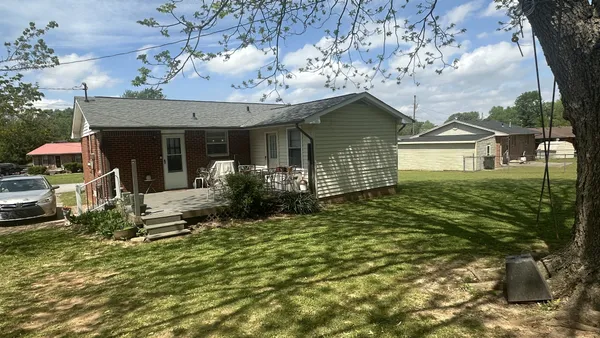 a view of a house with a small yard and potted plants