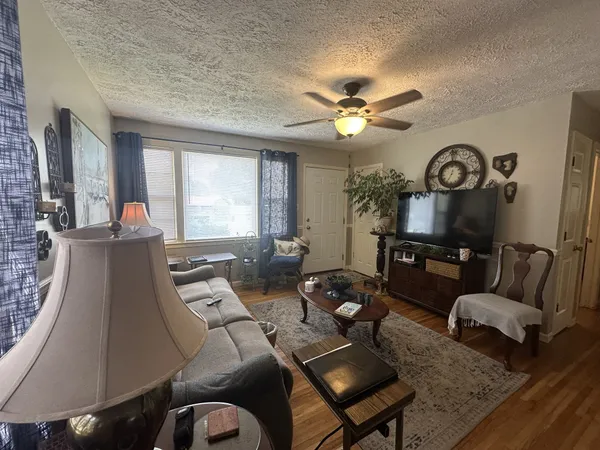 a living room with furniture floor to ceiling window and a flat screen tv