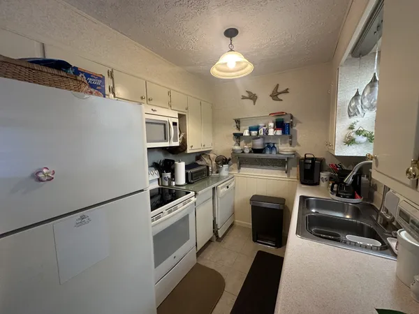 a kitchen with granite countertop a sink stainless steel appliances and cabinets