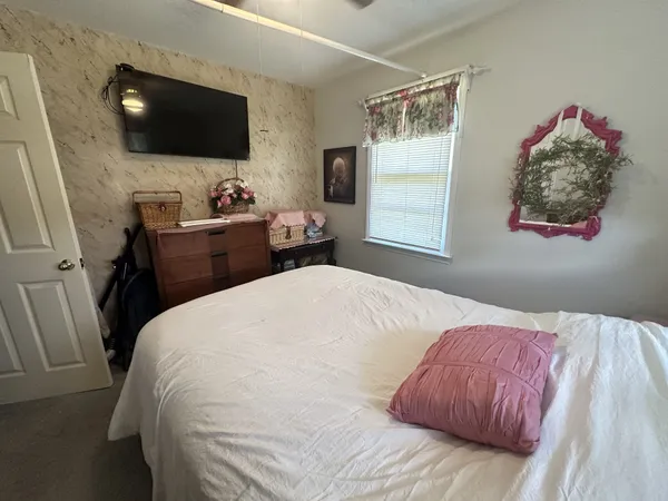 a bedroom with a large bed and a flat screen tv