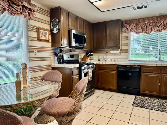 a kitchen with stainless steel appliances granite countertop a sink and a stove