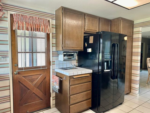 a kitchen with kitchen island granite countertop cabinets and refrigerator