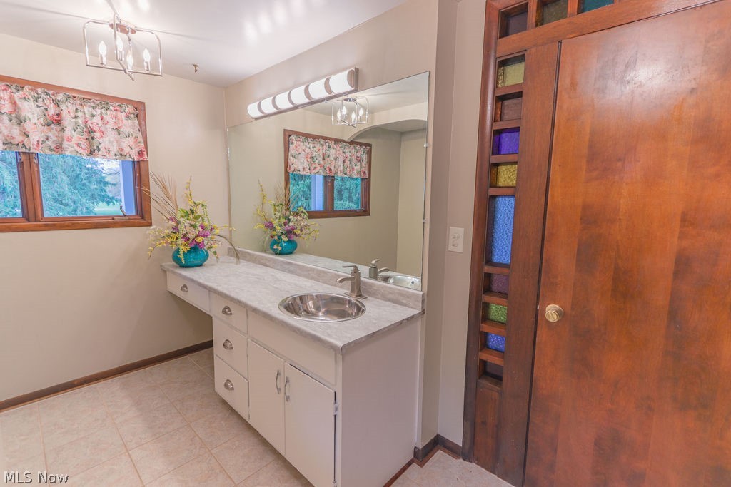 51883 Telegraph Road Amherst, OH 44001 - Photo 25 of 49 Bathroom featuring tile patterned flooring, vanity, and a notable chandelier