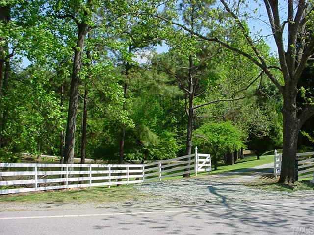 12624 Shooting Club Road Raleigh, NC 27613 - Photo 1 of 1 a view of a swimming pool with a lawn chairs and a large tree