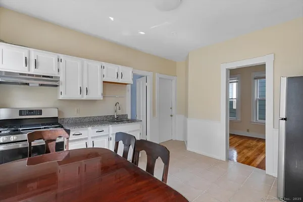 a kitchen with granite countertop a stove a sink and a refrigerator