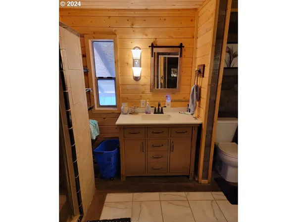 a bathroom with a sink a toilet and shower