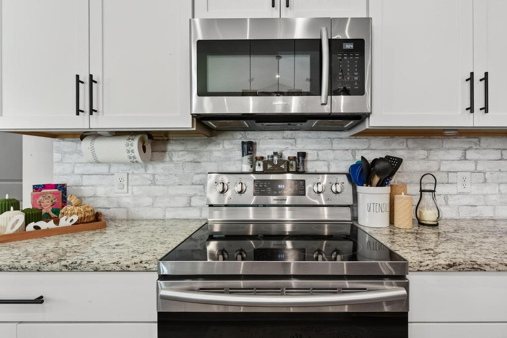 75774 Edwards Road Yulee, FL 32097 - Photo 21 of 70 a kitchen with granite countertop a stove and cabinets
