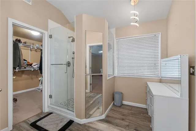 a view of walk in closet with clothes and shoes